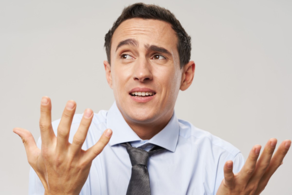 uomo preoccupato che gesticola con le mani