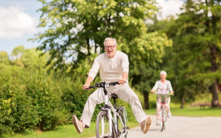 uomo e donna anziani sorridenti in bicicletta