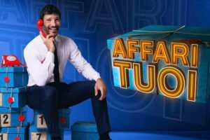 Stefano De Martini in posa con la scritta Affari tuoi