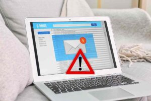 Pc con casella di posta elettronica aperta e simbolo di pericolo