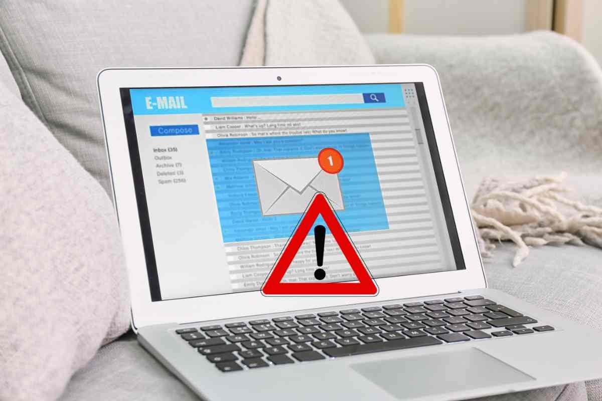 Pc con casella di posta elettronica aperta e simbolo di pericolo