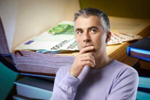 Uomo pensa e soldi nei libri