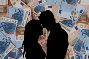 Soldi sullo sfondo e sagoma di una coppia