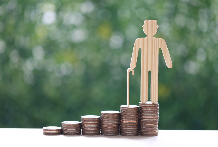 pila di monete e sagoma di anziano