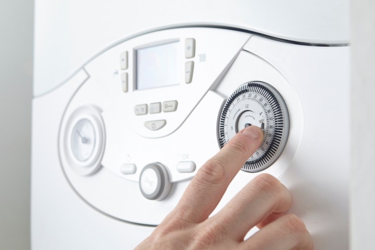 mano di donna su termometro caldaia