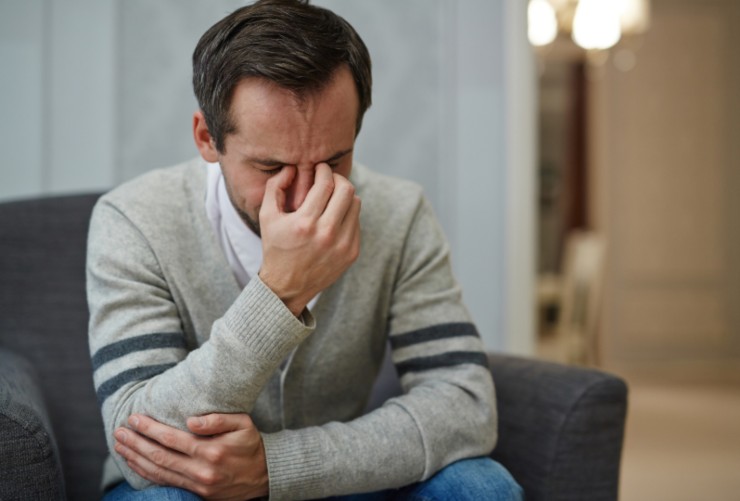 uomo disperato seduto sulla poltrona