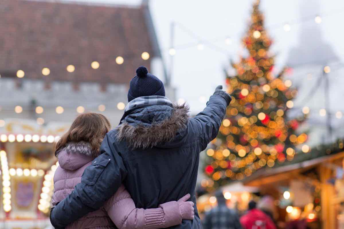 Coppia abbracciata e albero di Natale sullo sfondo