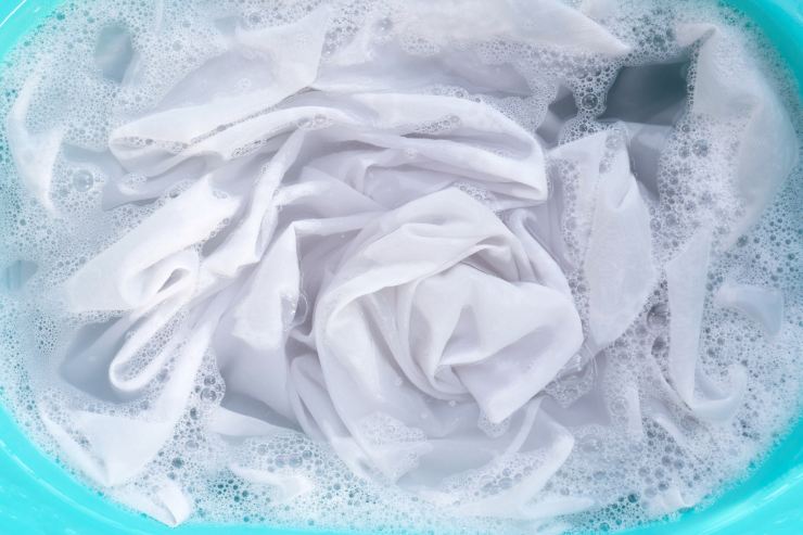 maglia bianca dentro una bacinella d'acqua e permanganato di potassio