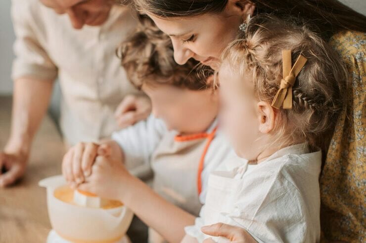 Bambini e mamma spremono arancia