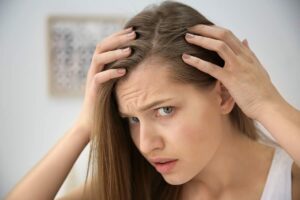 donna che si tocca radice capelli