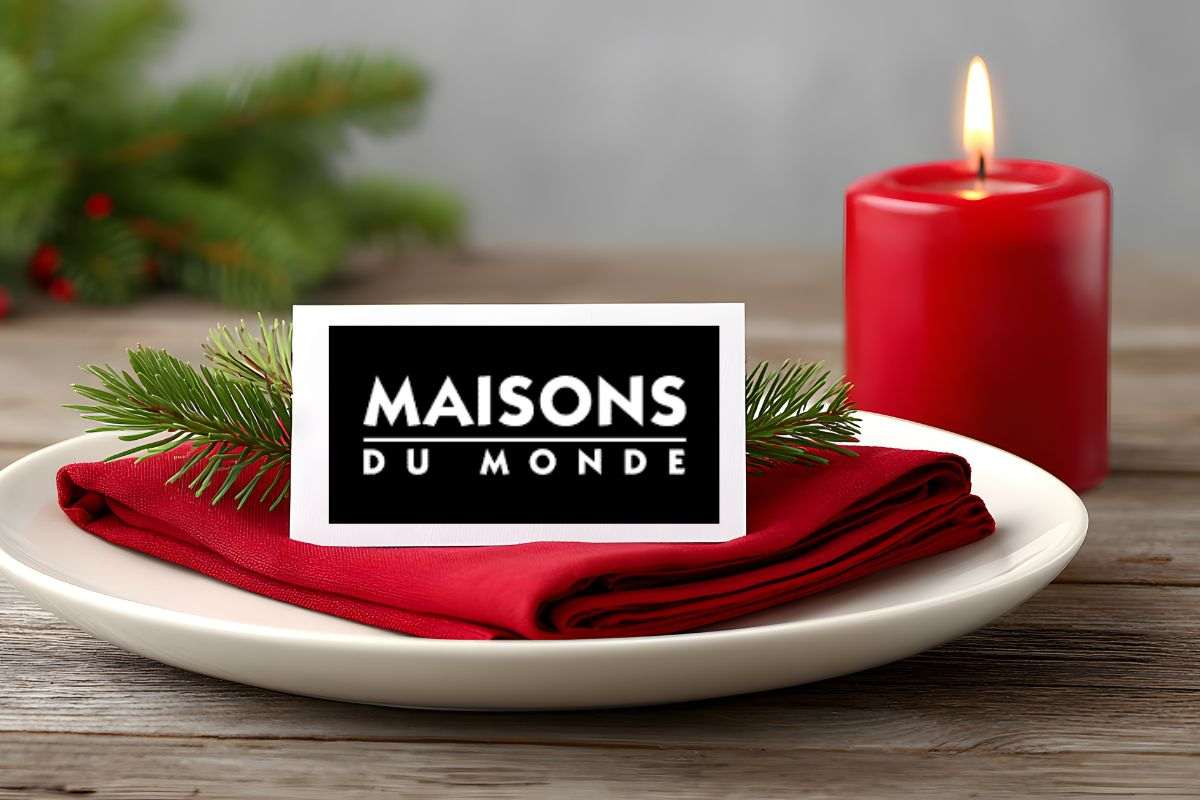 piatto con tovagliolo rosso e candela accesa, con logo maisons du monde