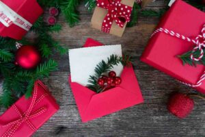 Busta rossa con lettera bianca, ramoscello verde, palline rosse