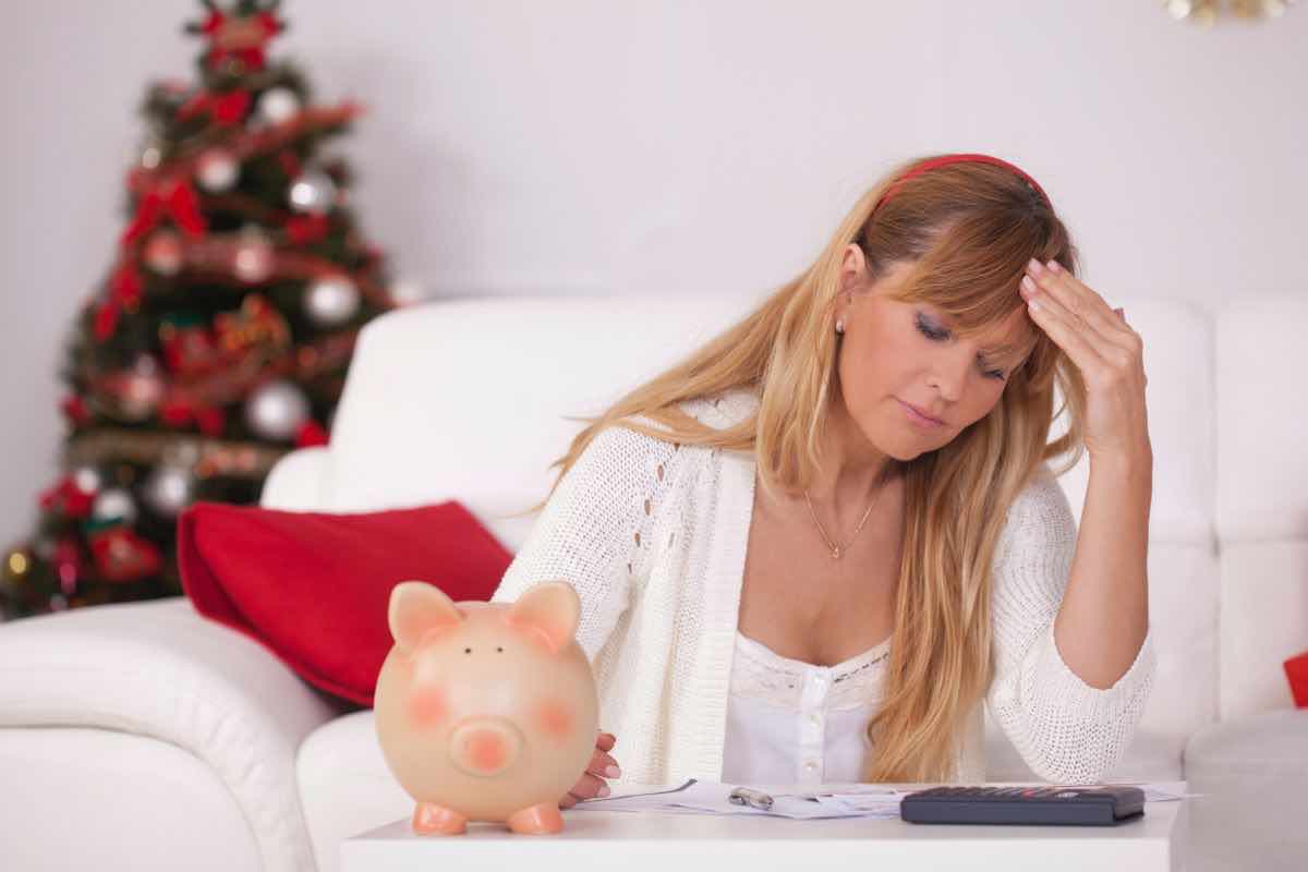 Donna con calcolatrice in mano e albero di Natale sullo sfondo